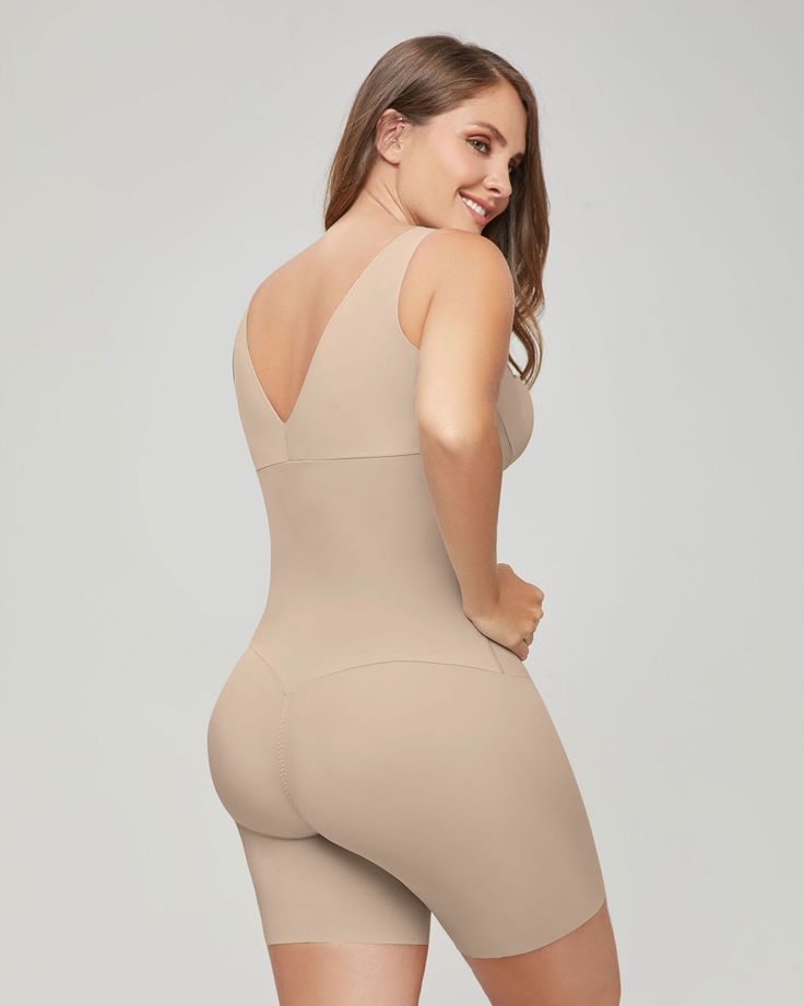 This mid-thigh bodysuit shaper is made with our trademark DuraFit® fabric for firm compression to sculpt the whole torso and thighs. Double-layered fabric in the torso carves out your curves, while the single-layered short bottom shapes lightly while preventing thigh rub. Laser-cut edges give this shaper a truly undetectable look, even under your tightest clothes. The plunge back is specially designed to shape the sides of your back while remaining undetectable, even when worn with scoop back dr Compression Shapewear With Seamless Construction, Solid Shapewear With Built-in Bra, Sculpting Shapewear With Built-in Bra For Workout, Compressive Full Coverage Shapewear For Workout, Compression Shapewear With Medium Bust Support For Workout, Full Coverage Shaping Shapewear For Workout, High Stretch Shapewear With Built-in Bra, Supportive High Stretch Seamless Shapewear, Compressive Seamless Shapewear