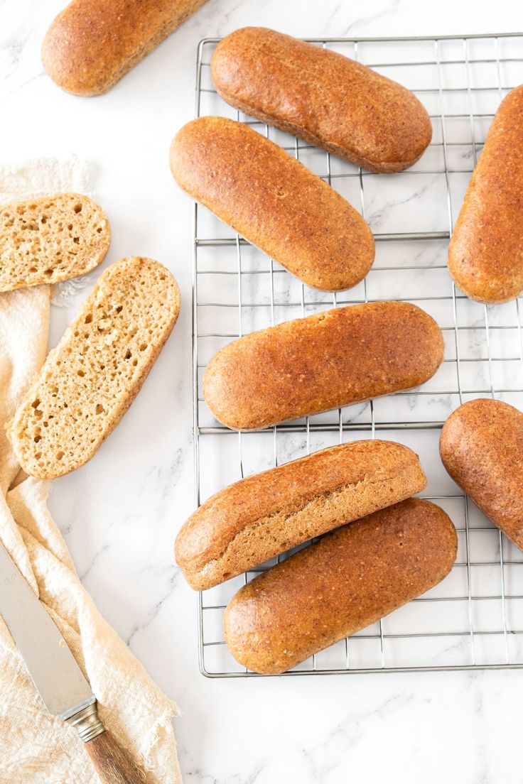 bread sticks cooling on a wire rack next to some slices of bread and a knife