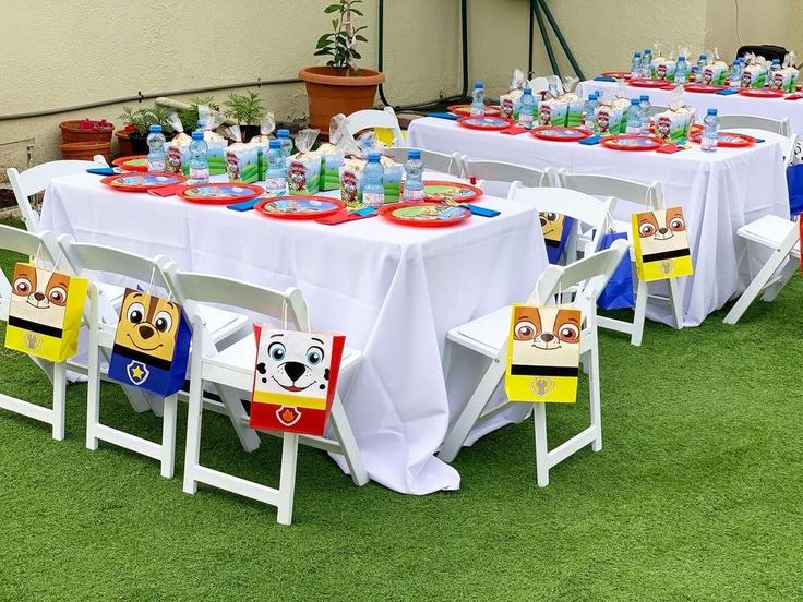 a table set up for a birthday party with cartoon characters on the tables and chairs