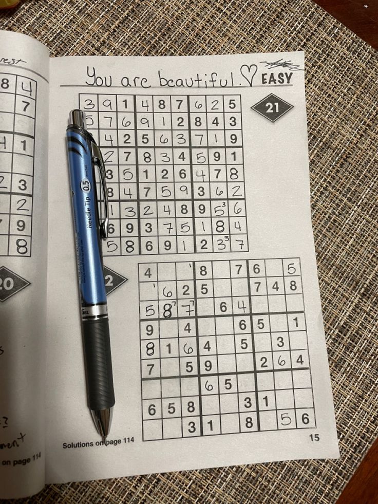 a pen sitting on top of an open sud puzzle book