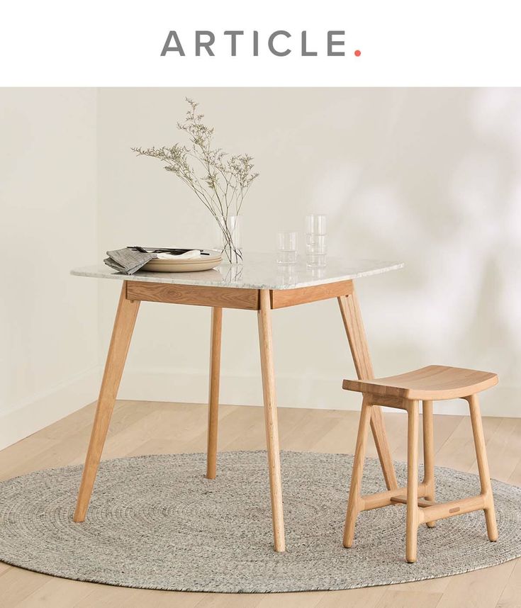 a table with two chairs sitting on top of it next to a vase and bowl