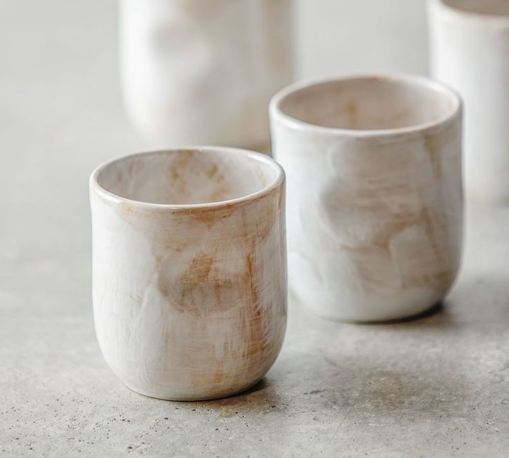 three white cups sitting on top of a table