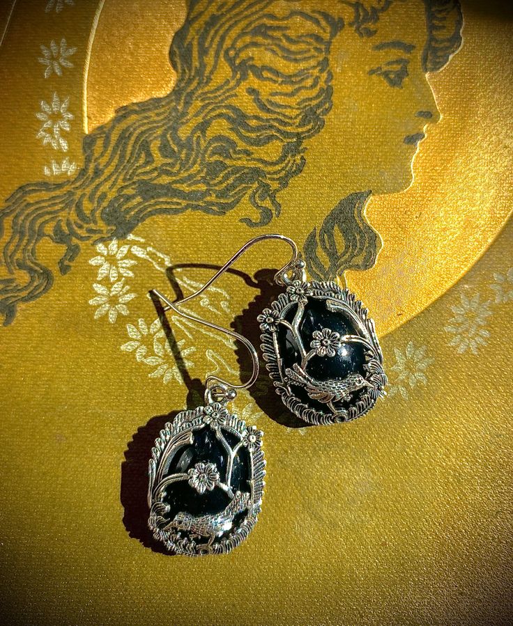 Inspired by the caged velvet perfume buttons from the Civil War era, a silver-plated overlay on faux black jet is the descendant of coveted mourning jewelry borrowed from the jewel box of someone’s great, great grandmother. These feather-light earrings with surgical steel French wires will complement gray and black attire. Both dressy and casual. 1” Vintage Handmade Jewelry For Evening, Handmade Vintage Jewelry For Evening, Ornate Filigree Jewelry For Evening, Victorian Oval Jewelry For Evening, Handmade Sterling Silver Jewelry For Evening, Art Deco Filigree Jewelry For Evening, Art Deco Drop Earrings For Evening, Oval Black Enamel Jewelry Gift, Victorian Style Drop Earrings For Party