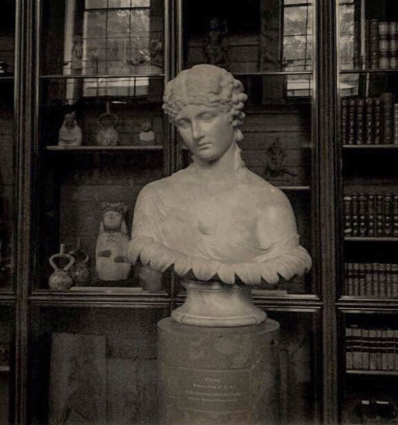 an old photo of a busturine in front of bookshelves