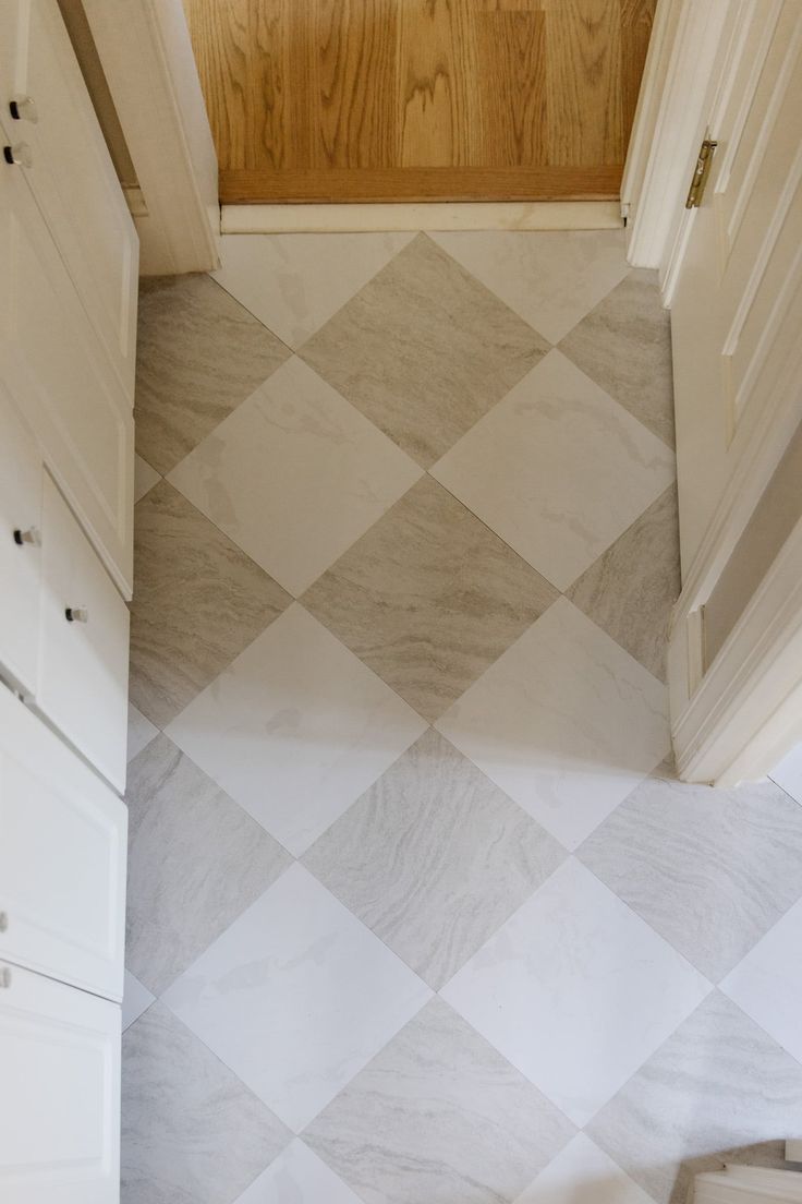 a white and grey tiled floor in a bathroom