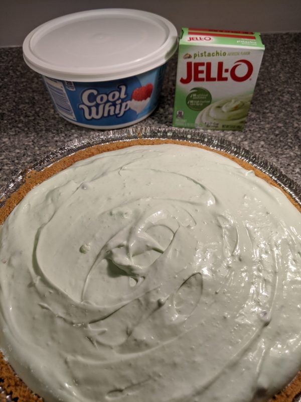 a cake with white frosting on it next to a container of jello