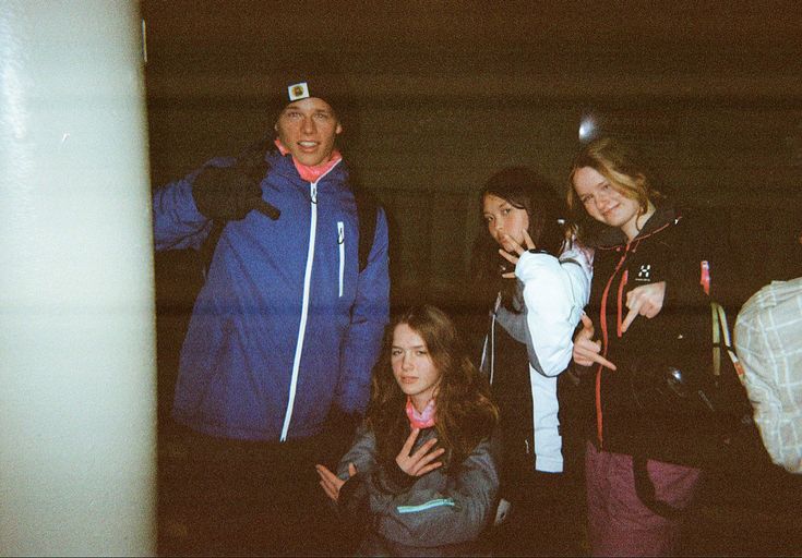 three women standing next to each other with one pointing at the camera and two smiling