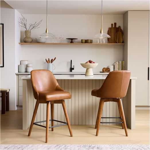 two brown chairs sitting next to each other on top of a wooden floored kitchen counter