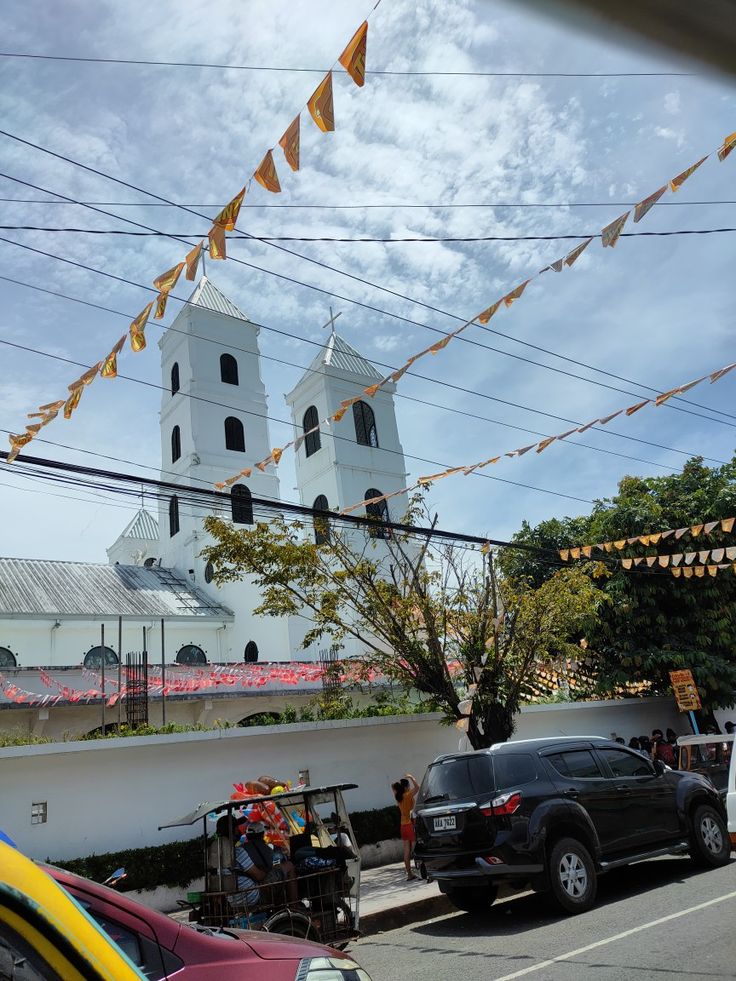 cars parked in front of a white church