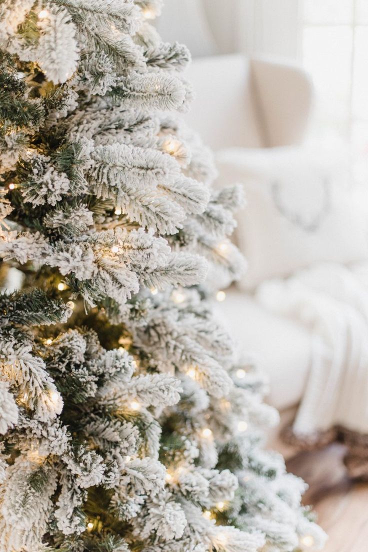 a white christmas tree in the corner of a living room