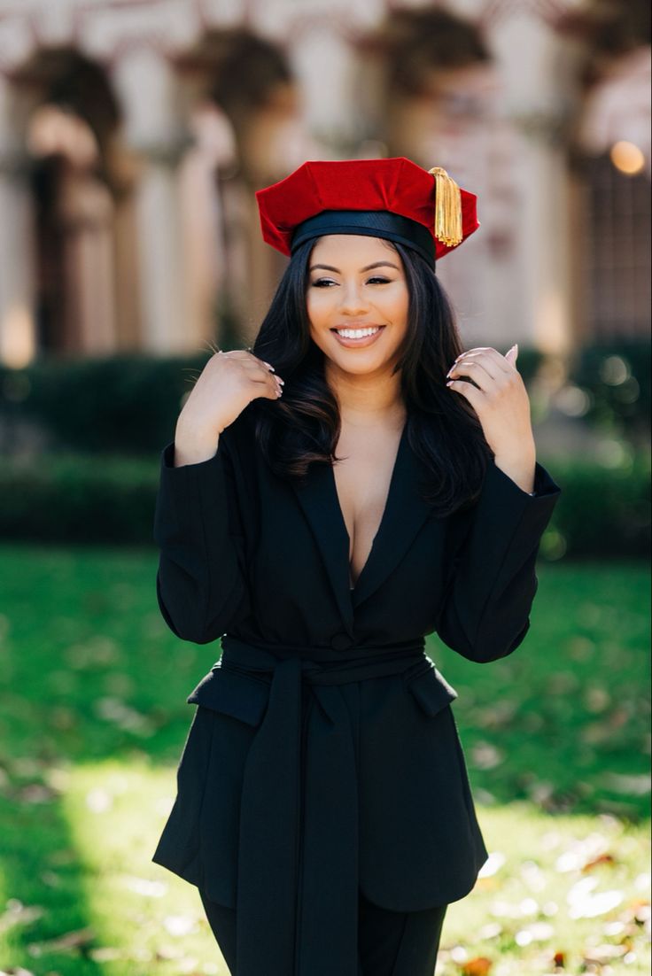 a woman in a graduation cap poses for a photo