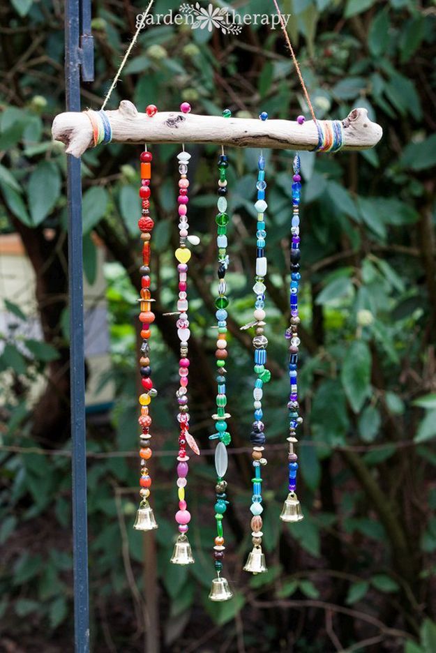 a wind chime with beads hanging from it's side in front of some trees