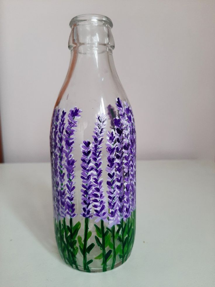 a glass bottle with purple flowers painted on it