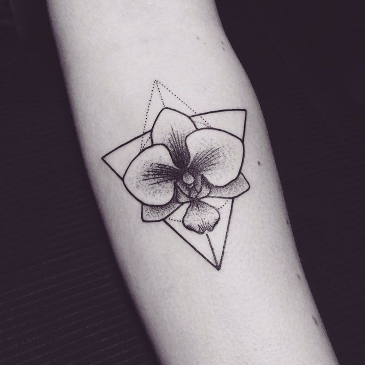 a black and white photo of a tattoo on someone's arm with a flower in the center