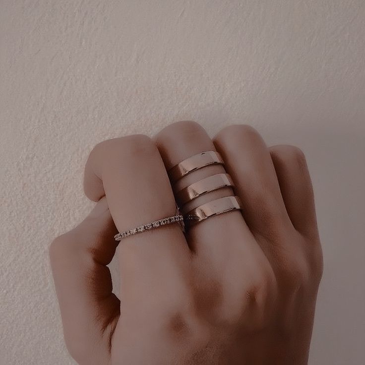 a woman's hand with three rings on it