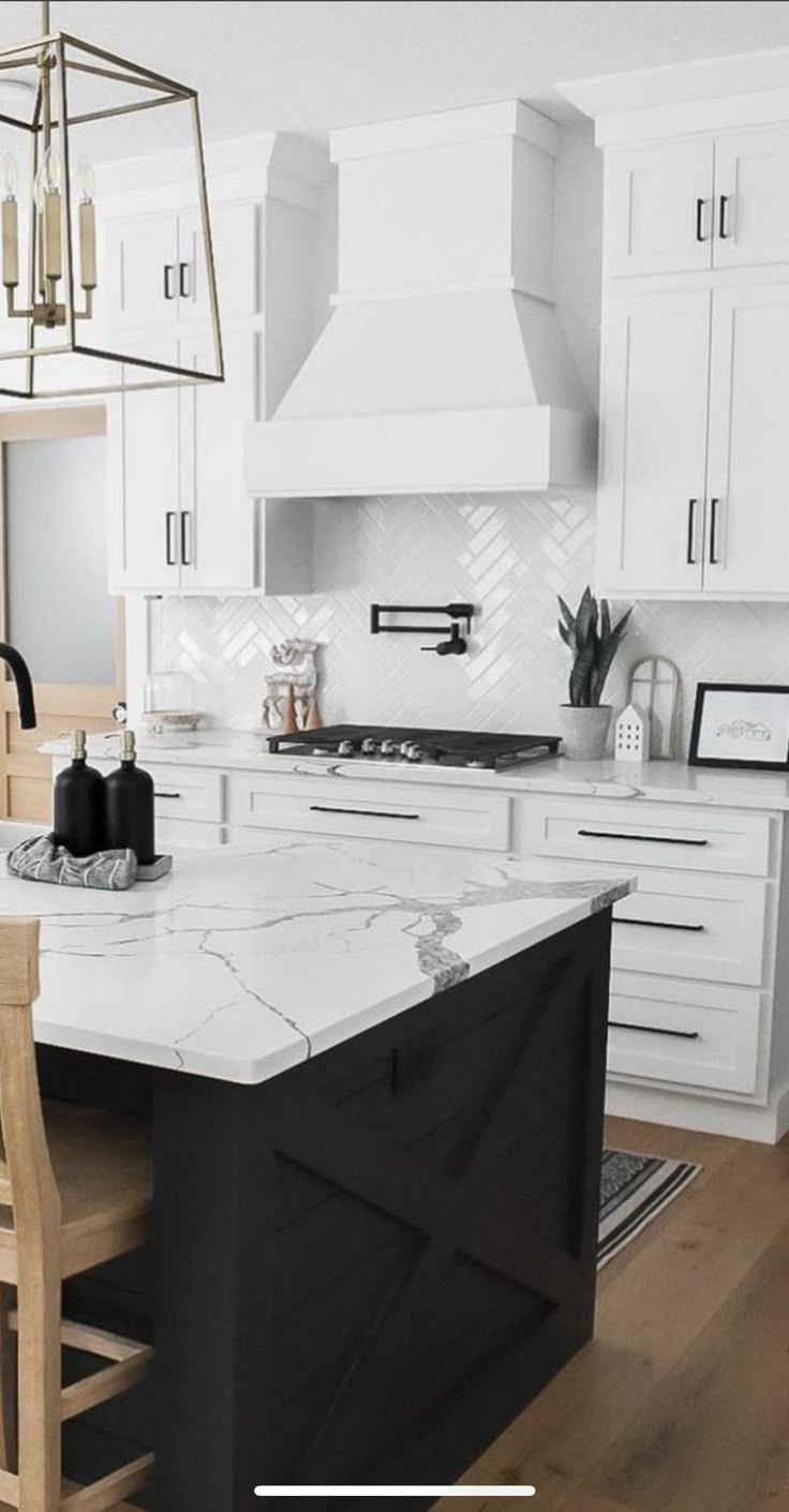 a kitchen with white cabinets and marble counter tops, an island in the middle is surrounded by wooden chairs