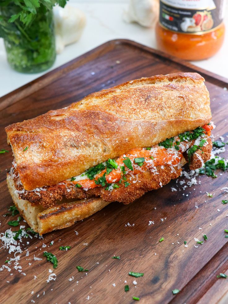 a sandwich on a cutting board with parmesan cheese