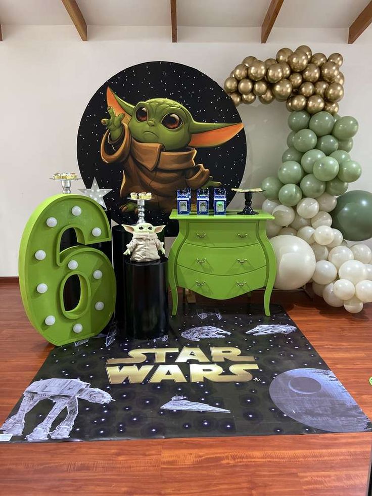 a star wars themed birthday party with balloons and decorations, including a green tablecloth