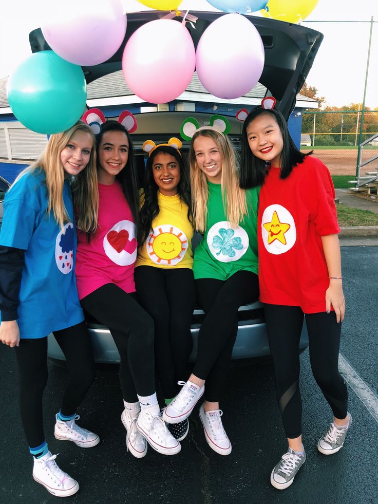 four girls standing in front of a car with balloons