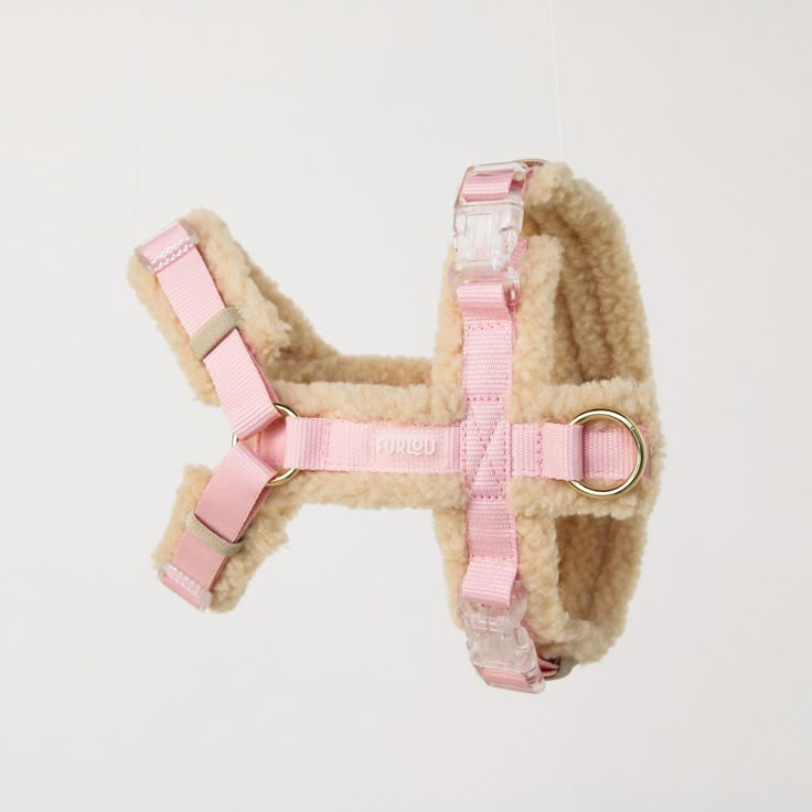 a pink dog harness attached to a white wall