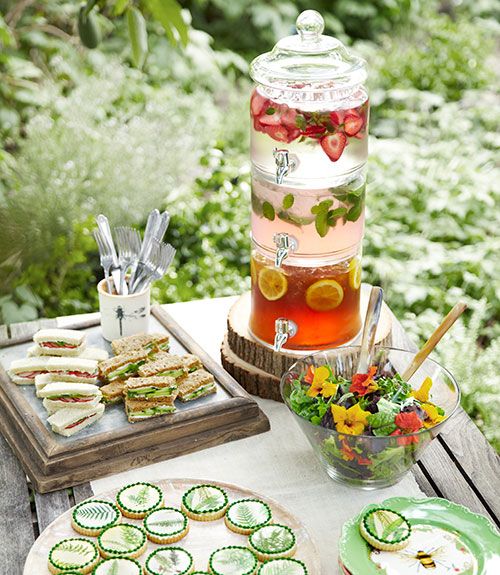 a picnic table with sandwiches and drinks on it