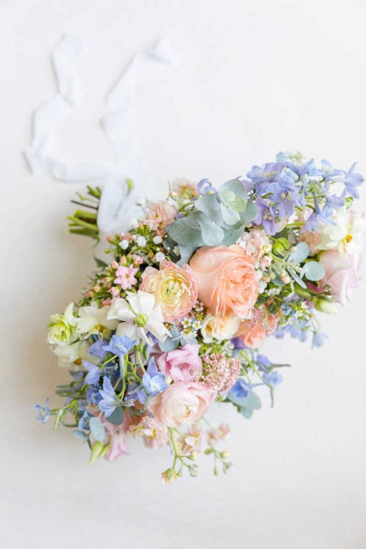 a bouquet of flowers sitting on top of a white table next to a paper bunny