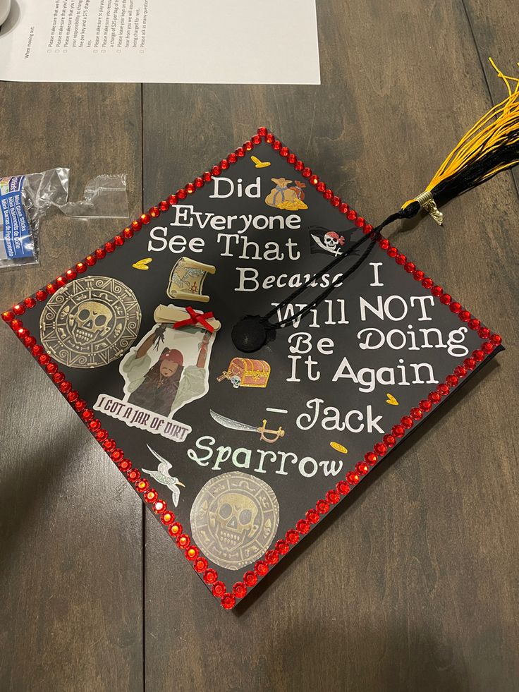 a graduation cap that has been decorated with images and words on it, sitting on top of a wooden table