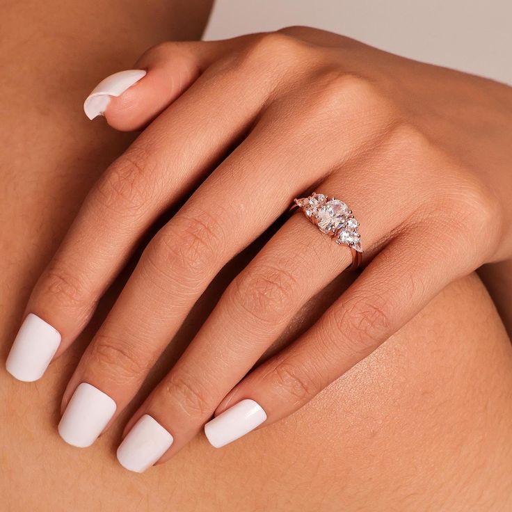 a woman's white manicured nails and ring