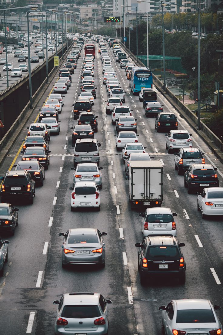 many cars are driving down the highway in heavy traffic, with one lane blocked off