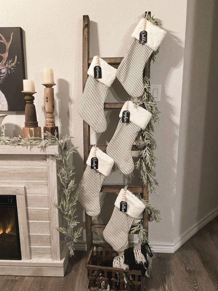 christmas stockings hanging from a ladder in front of a fireplace