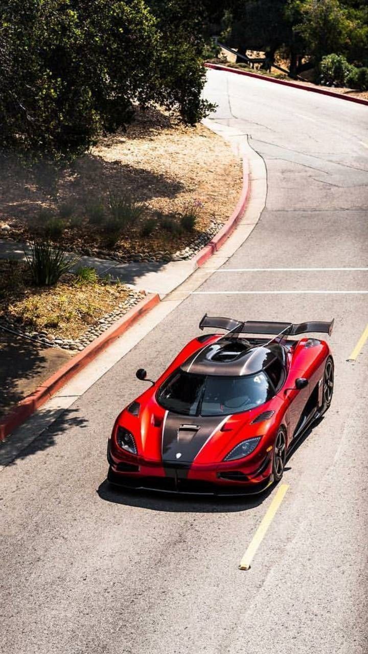 a red and black sports car driving down the road