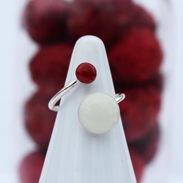 a close up of a ring on a stand with red balls in the back ground