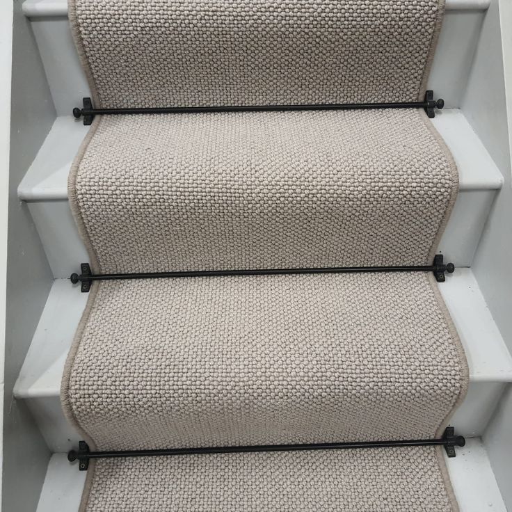 a set of stairs with carpeted treads and black piping on the bottom