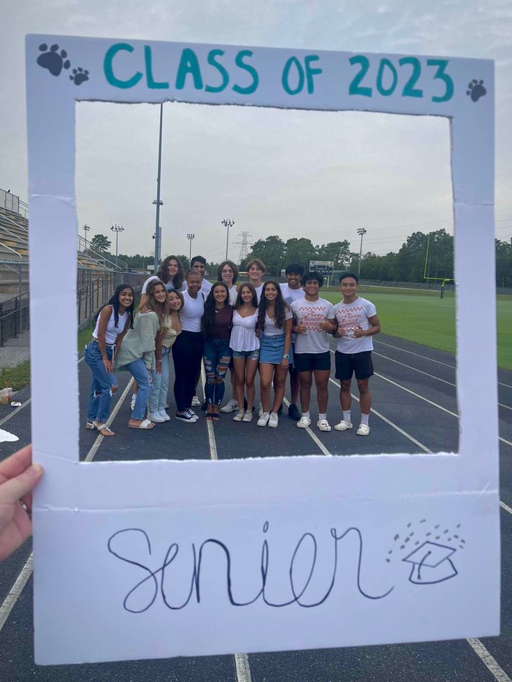 a group of people posing for a photo in front of a sign that says class of 2012