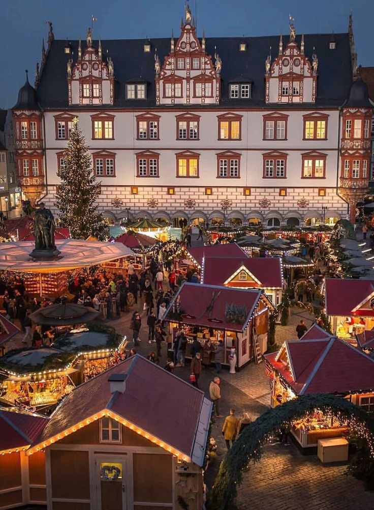 an aerial view of christmas markets in front of a large building