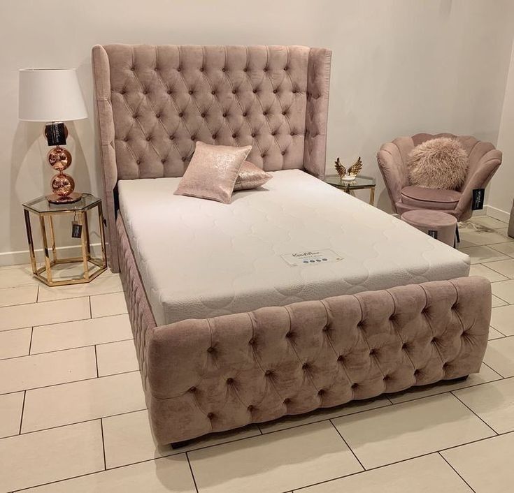 a bed with a tufted headboard and foot board is shown in a room