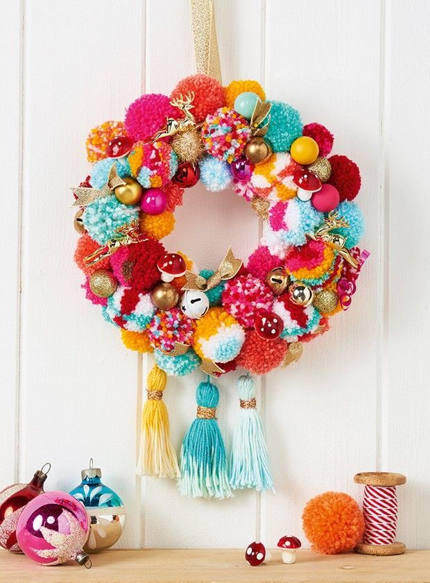 a colorful wreath hanging on the side of a white wall next to other ornaments and decorations