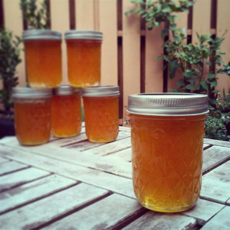 jars filled with honey sitting on top of a wooden table