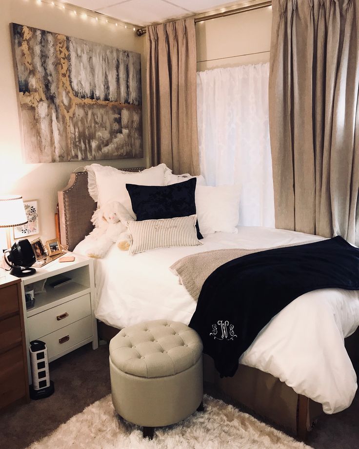 a bedroom with white and black bedding and curtains