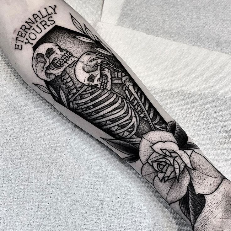 a man's arm with a skeleton and roses tattoo on it