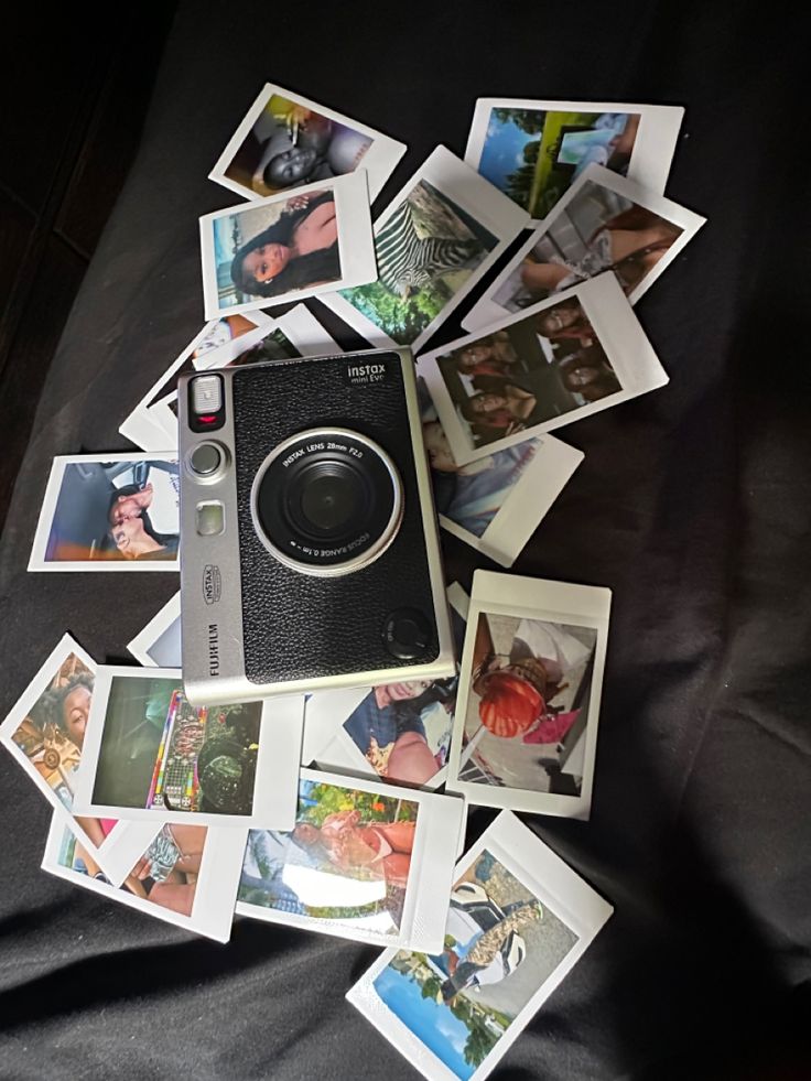 an old camera surrounded by polaroid pictures