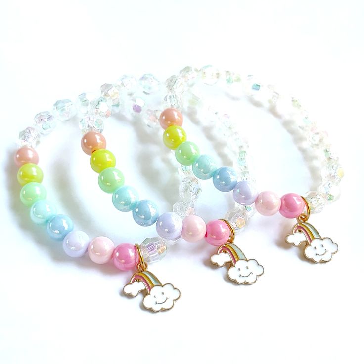 These adorable bracelets are the perfect favor for your little one's rainbow themed party! Each bracelet features a pastel enameled rainbow charm, a rainbow of pastel 10mm beads and white acrylic pearls strung with durable stretch floss cord. Each bracelet comes individually packaged in organza bags. Not quite what you are looking for? Request a custom order! I can match your bracelets to your other party decor. To be the first to know about new items, sales and giveaways, mark my shop as a favo Multicolor Hypoallergenic Jewelry For Birthday, Hypoallergenic Multicolor Jewelry For Birthday, Adjustable Rainbow Beaded Bracelets In Playful Style, Cute Round Beads Jewelry For Party Favors, Hypoallergenic Rainbow Beaded Bracelets For Friendship, White Kawaii Beaded Bracelets For Friendship, Rainbow Hypoallergenic Jewelry For Birthday, Rainbow Hypoallergenic Jewelry For Birthdays, Playful White Jewelry For Birthday