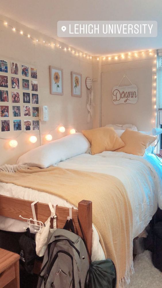 a bedroom with lights strung from the ceiling and pictures on the wall above the bed