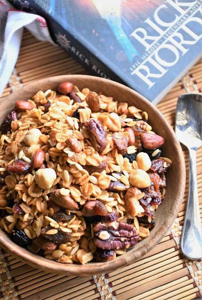 a bowl filled with granola and nuts next to a book