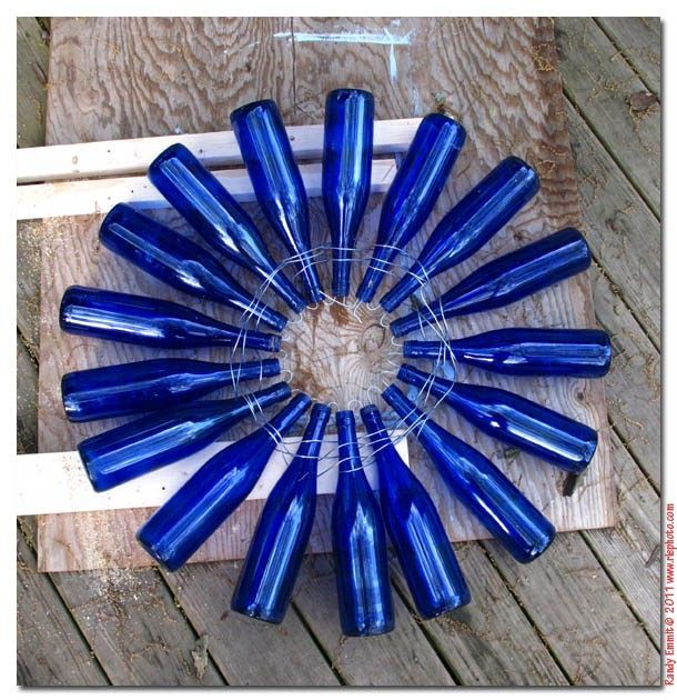 a bunch of blue bottles sitting on top of a wooden table