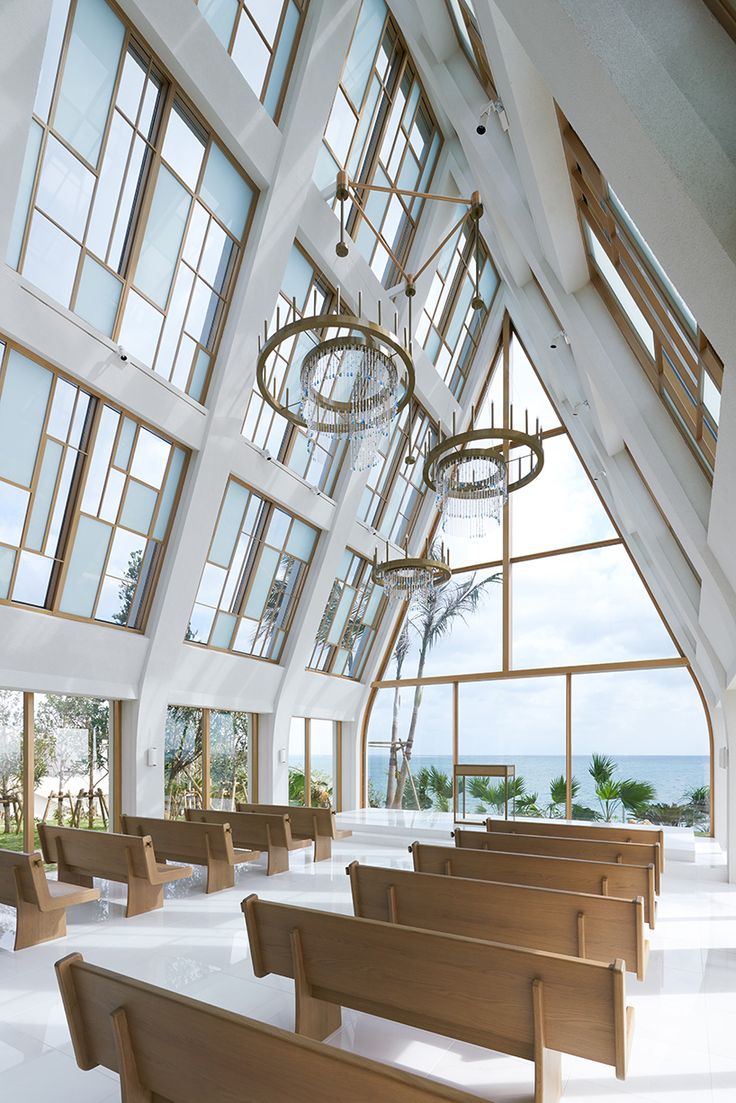 an empty church with large windows and chandeliers hanging from it's ceiling