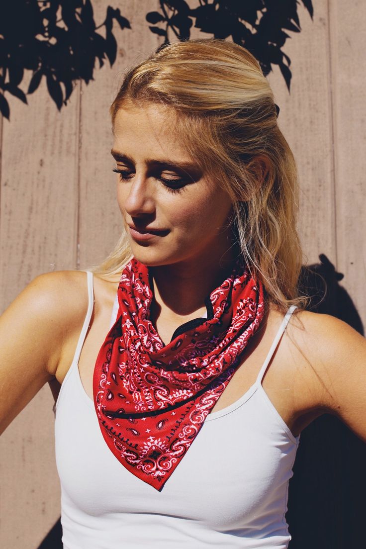 a woman wearing a white tank top and red bandana