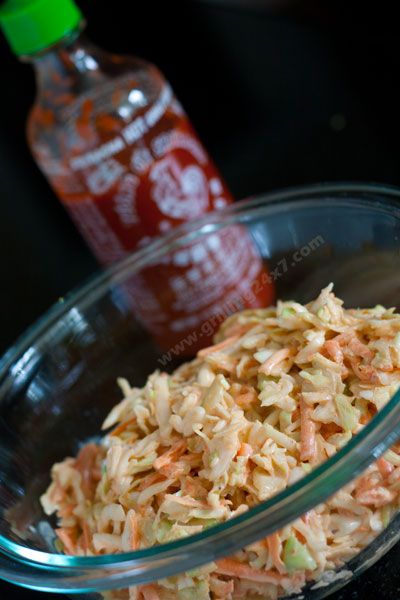 shredded carrots in a bowl next to a bottle of ketchup