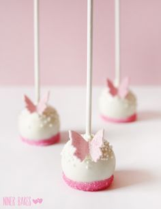 four cake pops with pink and white decorations