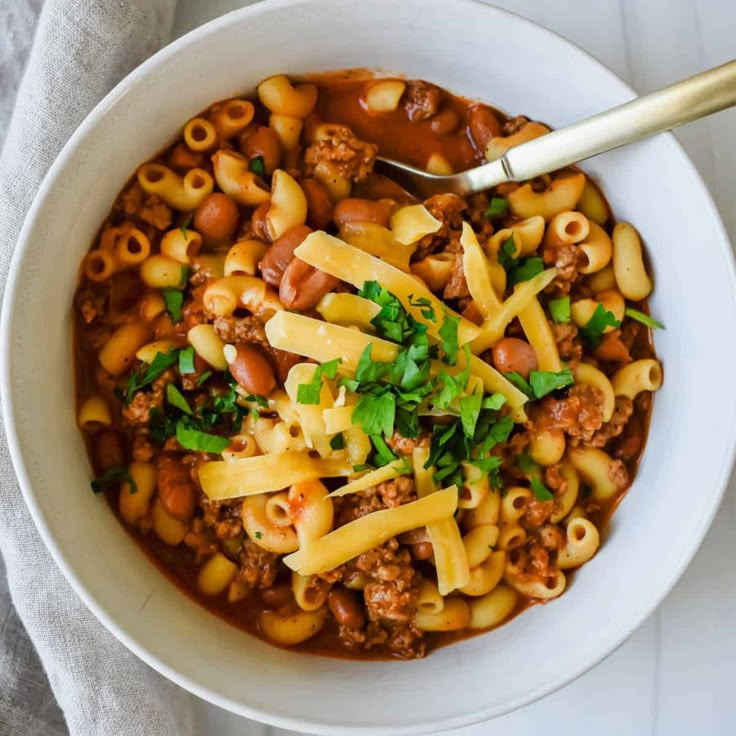 a white bowl filled with pasta and meat